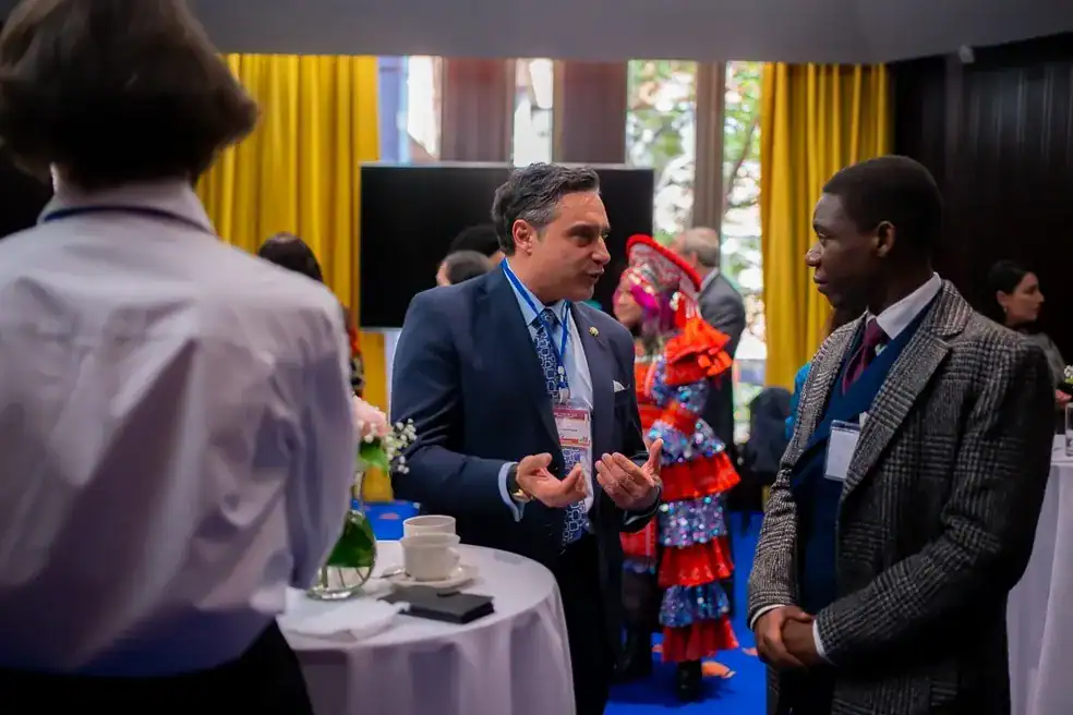 People at a professional intercultural event in a bright, colorful setting.