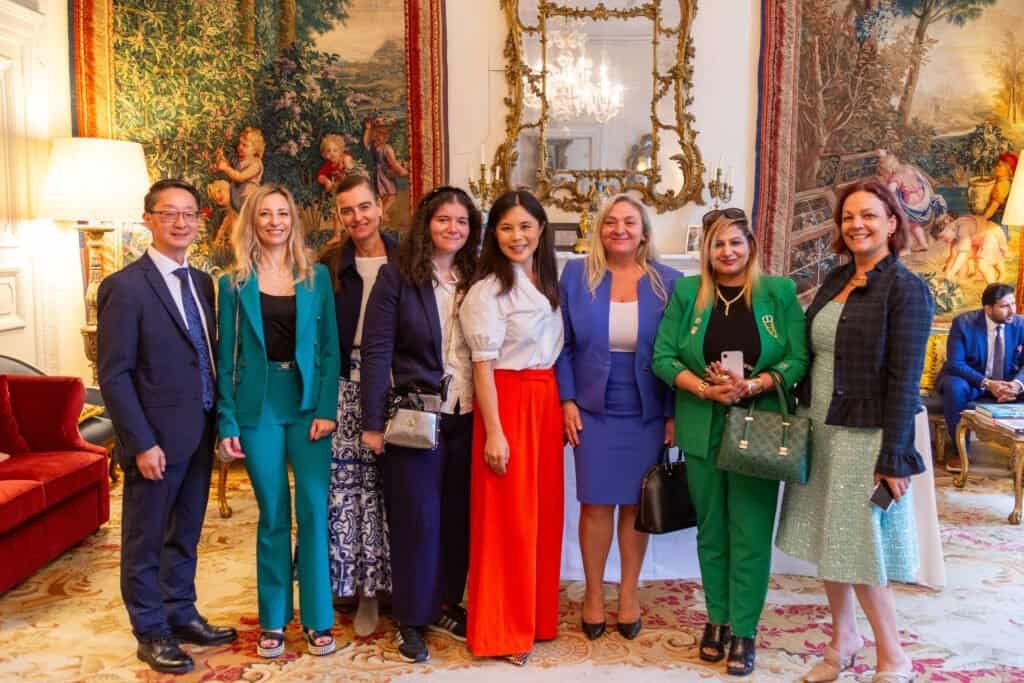 Group of diverse professionals posing in an elegant, decorated room.